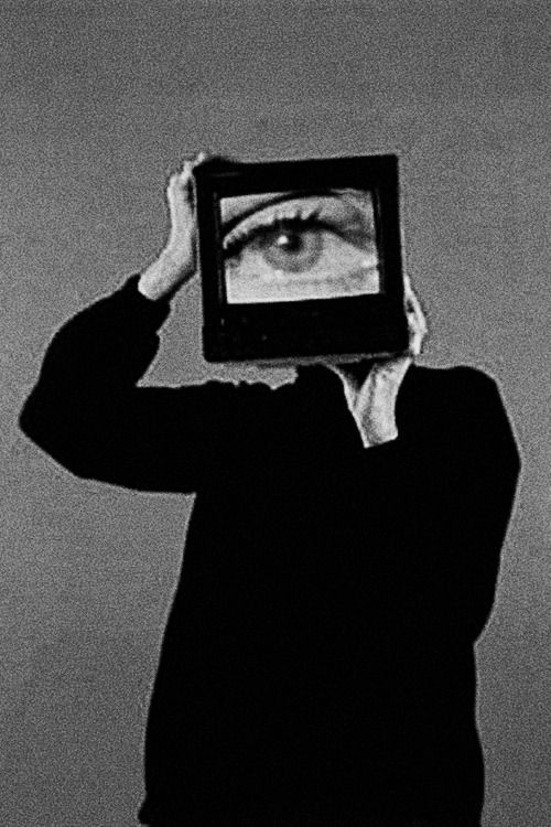 Figure holding a screen showing an eye